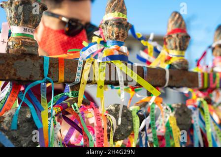 Salvador, Bahia, Brasilien - 01. Januar 2021: Frau mit Gesichtsmaske und Gebet in der Senhor do Bonfim Kirche in Salvador, Bahia, Brasilien. Stockfoto