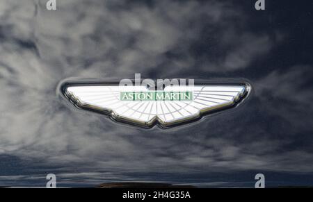 Nahaufnahme des Namensemblems des Aston Martin-Logos auf der Motorhaube eines schwarzen DBS-Sportwagens Stockfoto