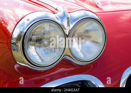 Nahaufnahme der Doppelscheinwerfer eines roten 1960-amerikanischen Klassikers Chevrolet Corvette C1 Stockfoto