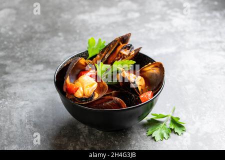 Gedünstete Muscheln in würziger Tomatensoße Stockfoto