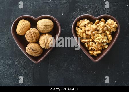 Die Walnüsse in einer herzförmigen Platte. Die Muttern Herz, Herz Gesundheit Produkte, Strukturierte Walnüsse Gesunde Ernährung Protein Stockfoto