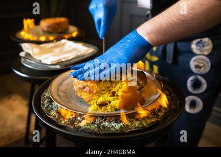 Shahs Pilaf. Serviert und schneidet Khans Pilaf in Lavasch im aserbaidschanischen Stil im Restaurant. Traditionelles orientalisches Gericht. Stockfoto