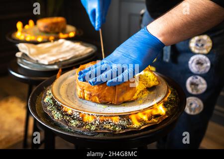 Shahs Pilaf. Serviert und schneidet Khans Pilaf in Lavasch im aserbaidschanischen Stil im Restaurant. Traditionelles orientalisches Gericht. Stockfoto