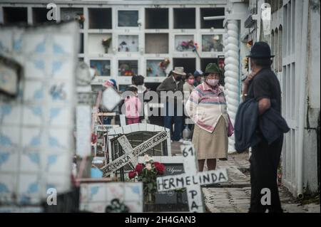 Ecuador. November 2021. Una mujer indigena y su esposo caminan por un pasillo deo cementerio de Calderon QUITO-ECUADOR, 2. November 2021. Nach zwei Jahren, in denen die Menschen die Friedhöfe Ecuadors nicht besucht haben, haben die Menschen diese Tradition wieder aufgenommen, in großer Zahl besuchten die Bewohner der Gemeinde Calderon in Quito ihren Verstorbenen auf dem zentralen Friedhof, der den gleichen Namen der Pfarrei trägt. (Foto: Juan Diego Montenegro/Sipa USA) Quelle: SIPA USA/Alamy Live News Stockfoto