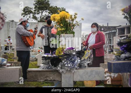 Ecuador. November 2021. Una mujer dedica una serenata para sus difuntos. QUITO-ECUADOR, 2. November 2021. Nach zwei Jahren, in denen die Menschen die Friedhöfe Ecuadors nicht besucht haben, haben die Menschen diese Tradition wieder aufgenommen, in großer Zahl besuchten die Bewohner der Gemeinde Calderon in Quito ihren Verstorbenen auf dem zentralen Friedhof, der den gleichen Namen der Pfarrei trägt. (Foto: Juan Diego Montenegro/Sipa USA) Quelle: SIPA USA/Alamy Live News Stockfoto