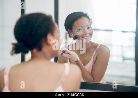 Eine hübsche, lockige Frau, die macht und erfreut aussieht Stockfoto