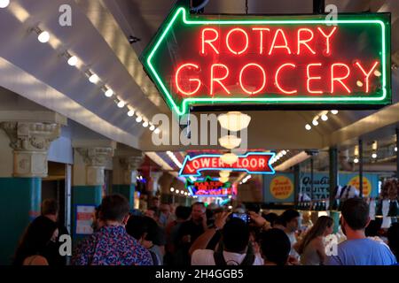 Menschenmassen im Public Market Center/Pike Place Market mit Neonschildern von Geschäften.Seattle.Washington.USA Stockfoto