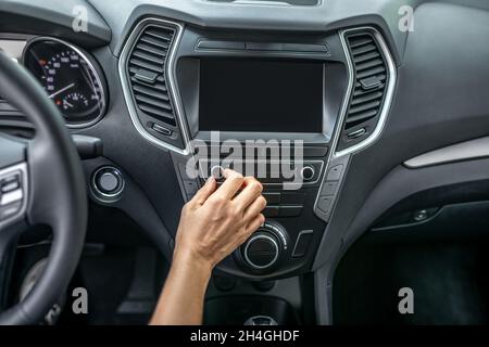 Frauen berühren das Armaturenbrett im Auto mit der Hand Stockfoto