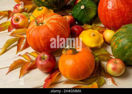 Erntedankfest Dekor mit roten, grünen, orangefarbenen Kürbissen, Kürbissen, Kürbissen, Äpfel auf dem weißen Holzhintergrund Stockfoto