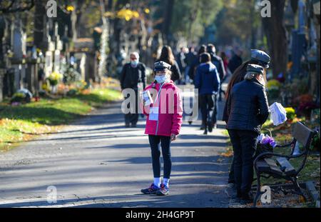 Krakau, Polen. November 2021. Ein kleines Mädchen, das während des Allerheiligen-Tages auf dem Rakowicki-Friedhof steht, einem traditionellen Fest auf den katholischen Friedhöfe in Krakau. (All Day of the Dead) Credit: SOPA Images Limited/Alamy Live News Stockfoto