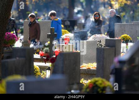 Krakau, Polen. November 2021. Menschen besuchen Gräber auf dem Rakowicki-Friedhof während des Allerheiligen-Tages, einem traditionellen Fest auf den katholischen Friedhöfe in Krakau. (All Day of the Dead) Credit: SOPA Images Limited/Alamy Live News Stockfoto