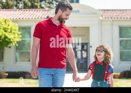 Vater unterstützt und motiviert Sohn. Kind geht zur Grundschule. Zurück in die Schule und glückliche Zeit. Stockfoto