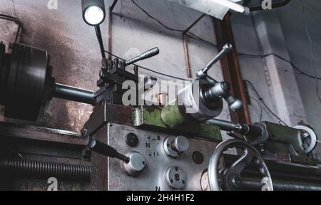 Alte Drehmaschine im Werk. Drehmaschine für die Metallbearbeitung. Herstellung schwerer Maschinen. Maschine zum Fräsen von Metall. Manuelle Drehmaschine. Stockfoto