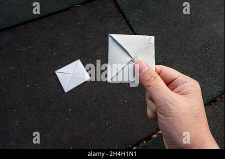 Eine Hand, die ein Papier-Ttakji auf einem Spielplatz hält Stockfoto