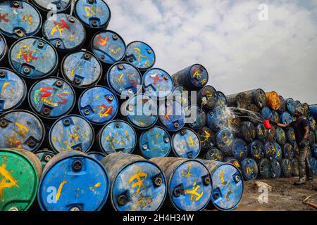 Dhaka, Bangladesch. November 2021. Ein Arbeiter sah in einem Lagerhaus in Dhaka leere Ölfässer zum Recycling waschen. (Foto von MD Manik/SOPA Images/Sipa USA) Quelle: SIPA USA/Alamy Live News Stockfoto