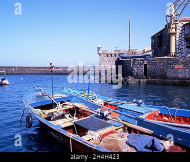 Blick auf den Hafen mit den Fischerbooten im Vordergrund, Puerto De La Cruz, Teneriffa, Kanarische Inseln, Spanien. Stockfoto