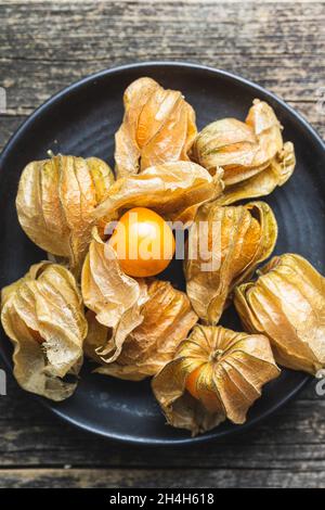 Physalis peruviana. Cape Gooseberry oder gemahlene Kirschen Früchte auf dem Teller. Draufsicht. Stockfoto