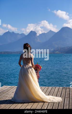 Ein ungewöhnlicher länglicher Brautstrauß in den Händen der Braut. Stockfoto