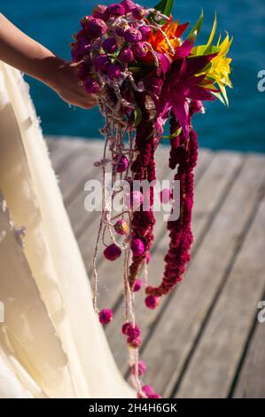 Ein ungewöhnlicher länglicher Brautstrauß in den Händen der Braut. Stockfoto