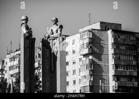 Bukarest, Rumänien - 27. Oktober 2021: Statue im kommunistischen/sowjetischen Stil, die Soldaten mit Wohnblöcken im Hintergrund darstellt. Stockfoto