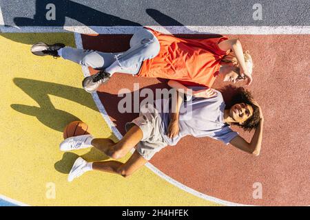 Interracial junges Paar aus im Freien, farbigen und modernen städtischen Hintergrund - multiethnische Menschen mit stilvollen und coolen städtischen Kleidung Bindung im Freien Stockfoto