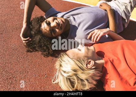 Interracial junges Paar aus im Freien, farbigen und modernen städtischen Hintergrund - multiethnische Menschen mit stilvollen und coolen städtischen Kleidung Bindung im Freien Stockfoto