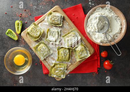 Konzept des Kochens von Ravioli auf dunklem Hintergrund Stockfoto