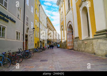 Salzburg Österreich - September 6 2017 :Reihe von Fahrrädern zwischen Franziskanerkirche und Gebäuden auf gepflasterter Stadtstraße Stockfoto