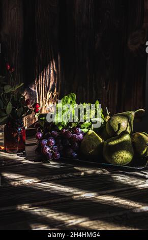 Herbstfrüchte. Stillleben. Ein Teil der Trauben und eine Birne im Fokus Stockfoto