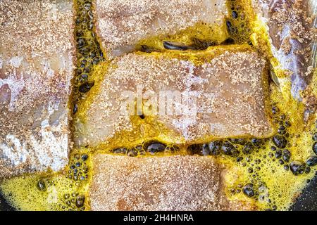 Panierte weiße Fischsteaks, in einer Pfanne mit Pflanzenöl gebraten. Stockfoto