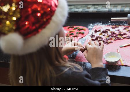 Happy girl macht bunte Pasta für Weihnachtsessen in der Küche Stockfoto