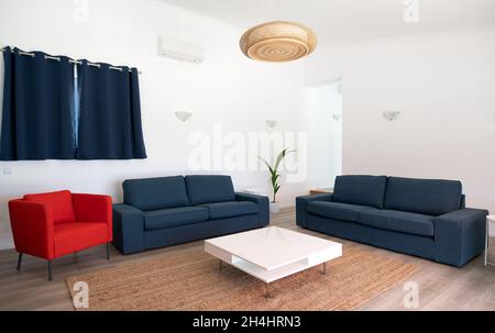 Modernes Wohnzimmer mit weißen Wänden und blauen Sofas Stockfoto