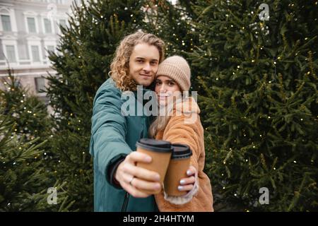 Nettes Paar mit Winter Forest Picknick trinken Tee aus Tee Take Away Cup. Natur-Picknick. Datum Der Liebesgeschichte Stockfoto