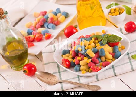 Farbige Gnocchi mit Gemüse und süßem Mais. Stockfoto