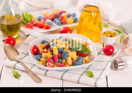 Farbige Gnocchi mit Gemüse und süßem Mais. Stockfoto