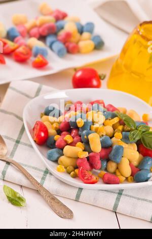 Farbige Gnocchi mit Gemüse und süßem Mais. Stockfoto