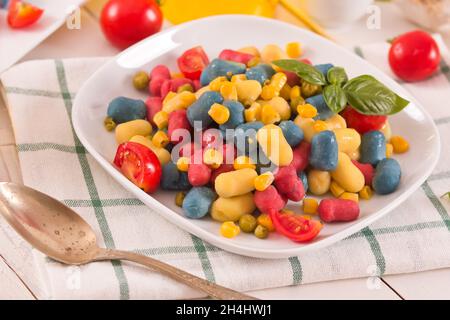Farbige Gnocchi mit Gemüse und süßem Mais. Stockfoto