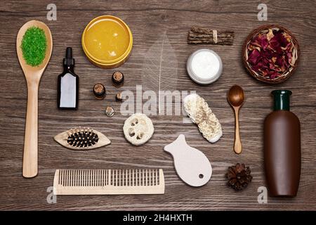 Spa-Produkte und Accessoires flach auf Holzhintergrund gelegt. Natürliche Pflege- und Haarpflegekosmetik Stockfoto