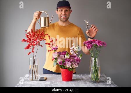 Porträt eines männlichen Floristen. Blumenstrauß, für zu Hause eingestellt. Frische Schnittblumen für die Dekoration zu Hause. Europäischer Blumenladen. Lieferung frisch geschnittene Blume. Stockfoto