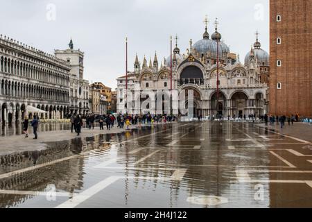 Venedig, Italien. November 2021. Touristen gehen bei einer Flut am 3. November 2021 in Venedig, Italien, auf einem überfluteten Markusplatz spazieren. In diesen Tagen ist Venedig aufgrund der hohen Flut für den Klimawandel unter Wasser, und Mose ist aktiviert, aber nicht ausreichend. © Simone Padovani / Erwachen / Alamy Live News Stockfoto