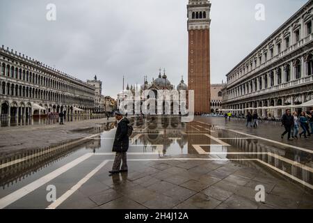 Venedig, Italien. November 2021. Touristen gehen bei einer Flut am 3. November 2021 in Venedig, Italien, auf einem überfluteten Markusplatz spazieren. In diesen Tagen ist Venedig aufgrund der hohen Flut für den Klimawandel unter Wasser, und Mose ist aktiviert, aber nicht ausreichend. © Simone Padovani / Erwachen / Alamy Live News Stockfoto