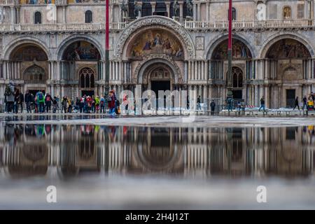 Venedig, Italien. November 2021. Touristen gehen bei einer Flut am 3. November 2021 in Venedig, Italien, auf einem überfluteten Markusplatz spazieren. In diesen Tagen ist Venedig aufgrund der hohen Flut für den Klimawandel unter Wasser, und Mose ist aktiviert, aber nicht ausreichend. © Simone Padovani / Erwachen / Alamy Live News Stockfoto