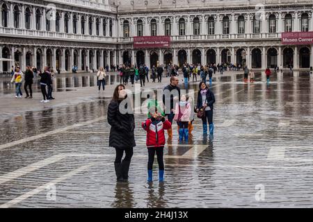 Venedig, Italien. November 2021. Touristen gehen bei einer Flut am 3. November 2021 in Venedig, Italien, auf einem überfluteten Markusplatz spazieren. In diesen Tagen ist Venedig aufgrund der hohen Flut für den Klimawandel unter Wasser, und Mose ist aktiviert, aber nicht ausreichend. © Simone Padovani / Erwachen / Alamy Live News Stockfoto