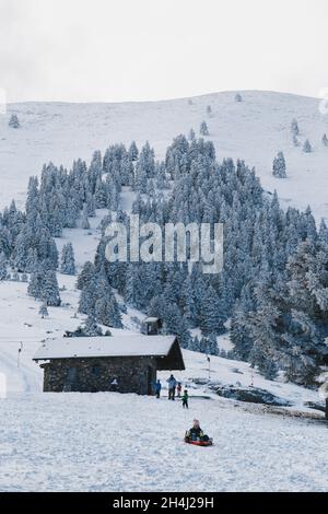 Kalavryta Skigebiet, Griechenland - Dezember, 31 2019: Glückliche Kinder mit Vater genießen Winterurlaub im Skigebiet in Griechenland. Kinder haben Spaß im Freien Stockfoto