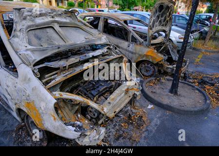 Verbrannte Autos auf dem Parkplatz auf der Straße. Aufruhr, ziviler Protest, Hooliganismus in der Stadt. Explosion, Feuer. Auto Stockfoto