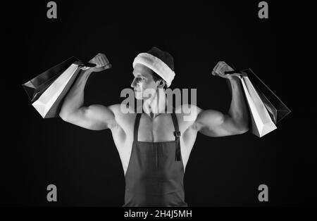 Fit weihnachtsmann halten Einkaufstaschen Beugen muskulösen Armen Bizeps Trizeps weihnachtsvorbereitung, stark Stockfoto