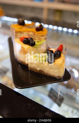 Verschiedene Kuchen auf einem schwarzen Teller beim Kochen. Stockfoto