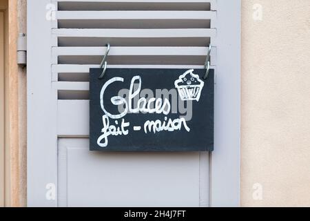 Nahaufnahme eines Schiefer-Schreibens, der an einem Fensterladen befestigt ist und auf Französisch sagt: Glaces fait maison - was auf Englisch bedeutet - hausgemachtes Eis. Stockfoto