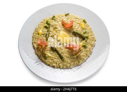 Risotto mit Spargel in weißem Gericht isoliert auf weißem Hintergrund, italienische Reis Gourmet-Rezept Stockfoto