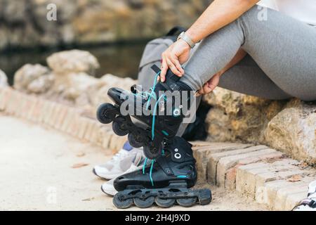 Nicht erkennbarer junger Mann, der in einem Park auf Inline-Skates padelt Stockfoto